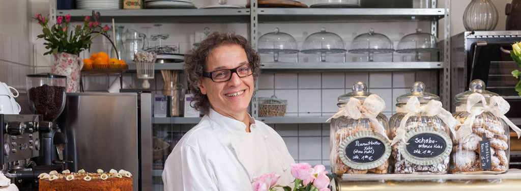 Joseph Martin hinter der Theke seines Cafés, im Hintergrund Keksgläser